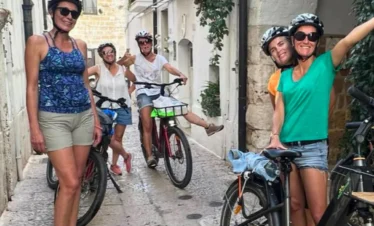 Riders relaxing in the shade of a vineyard after cycling in Puglia