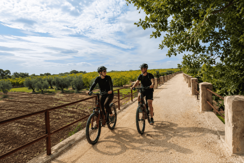 Cyclists exploring rural Puglia by e-bike without needing a car